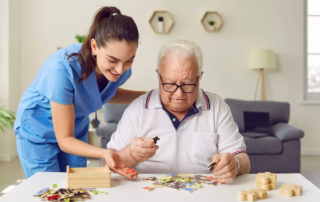 Team member in a memory care center helping senior with an alphabet puzzle game.